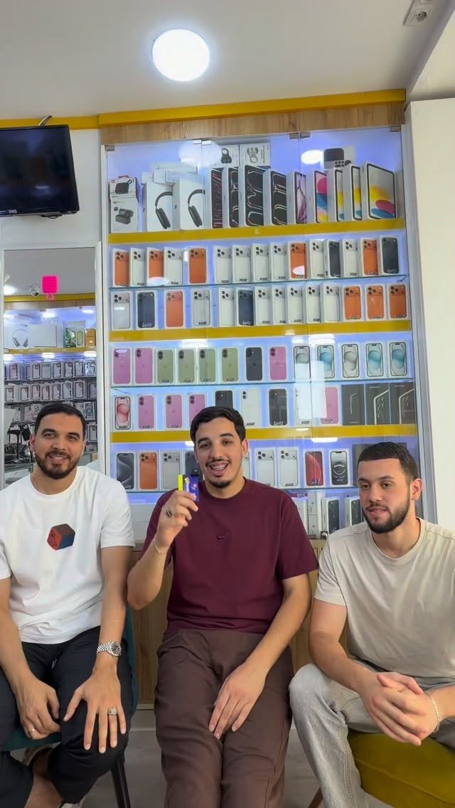 L'équipe Val Phone devant le mur de coques de la boutique